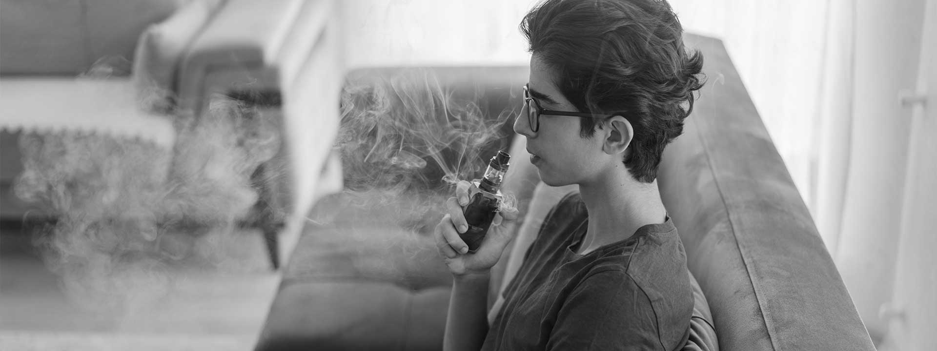 One young teenager vaping at home